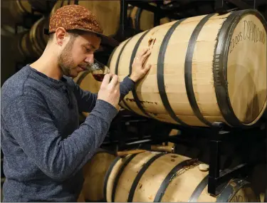  ?? JULIO CORTEZ — THE ASSOCIATED PRESS ?? Eli Breitburg-smith, head distiller and co-owner of Baltimore Spirits Company, checks the quality of rye whiskey from a barrel on Wednesday. Spirits have surpassed beer for U.S. market share supremacy, led by a resurgent cocktail culture — including the popularity of ready-to-drink concoction­s, according to a spirits industry group.