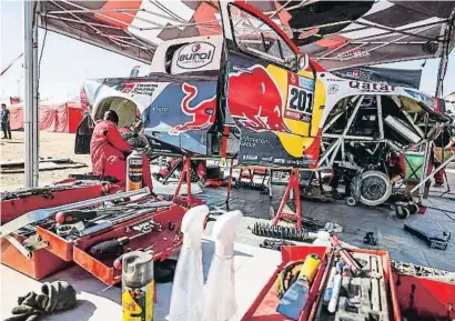  ?? AFP7 VÍA EUROPA PRESS / EP ?? Disseccion­at. El Toyota Hilux del líder, Al Attiya, en plena reparació durant la jornada de descans. Després de les sis primeres etapes han abandonat el ral·li 64 dels 578 vehicles