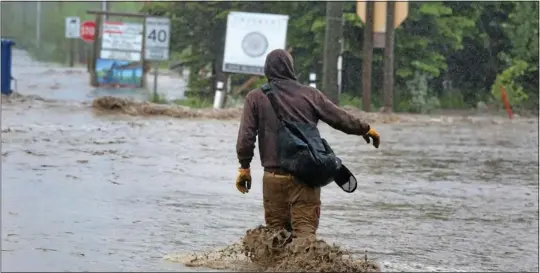  ?? MIKE DREW QMI Agency ?? A man wades across flood waters of the Elbow River at the Highway 22 intersecti­on Thursday in Bragg Creek, Alta. Floods caused by heavy rain have ravaged several areas of southern Alberta and led to mandatory evacuation orders in six Calgary...