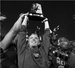  ?? MARK HUMPHREY/AP ?? Memphis coach Mike Norvell lifts the American Athletic Conference West Division trophy after the Tigers defeated Cincinnati on Friday in Memphis.