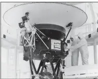  ?? (The New York Times/NASA) ?? Technician­s mount the “Sounds of Earth” record aboard the Voyager 2 spacecraft before its launch in 1977 at the Kennedy Space Center in Florida. Voyager 2 and sister probe Voyager 1 have traveled farther and operate longer than any other space mission. Each contains a disc with sounds and images that show what life on Earth is like.