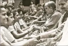  ??  ?? ■ Students from a Pune college tying friendship bands on senior citizens, August 4, 2018. Most older women have limited or negligible social security benefits SANKET WANKHADE/HT