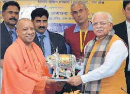  ?? HT PHOTO ?? Haryana chief minister Manohar Lal Khattar presenting a memento to Uttar Pradesh CM Yogi Adityanath at the inaugural function of Surajkund Crafts Mela in Faridabad on Friday.