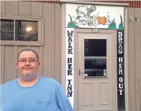  ?? JIM STINGL MILWAUKEE JOURNAL SENTINEL ?? Kristian Plumeri, who owns the bar with his wife, Diane, stands in front of the signs at the entrance. A woman complained that the signs and wording promote violence and a negative image of women. Her social media concerns went viral.