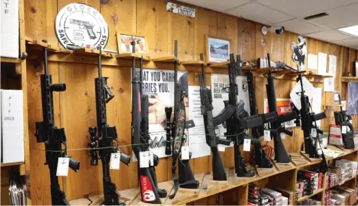  ?? SCOTT OLSON/GETTY IMAGES ?? Assault-style rifles now banned for sale in Illinois are displayed at a sporting goods store on Jan. 11 in Tinley Park.