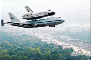  ?? SMILEY N. POOL/THE ASSOCIATED PRESS ?? The space shuttle Endeavour, carried atop NASA’s 747 Shuttle Carrier Aircraft, passes over neighborho­ods near Hobby Airport in Houston on Wednesday.