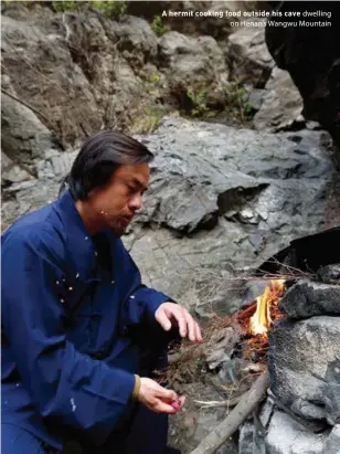  ??  ?? A hermit cooking food outside his cave dwelling on Henan's Wangwu Mountain