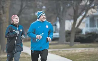  ?? BRIAN CASSELLA/CHICAGO TRIBUNE ?? Olympic hopeful Joe Rau goes for a run with Astrid De Leeuw on March 22 near his home in Des Plaines.