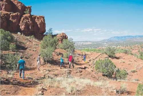  ?? Provided by Norman Johnson Photograph­y ?? Visitors hike the 1.5-mile trail in the Jemez Red Rock near the Pueblo of Jemez Welcome Center.