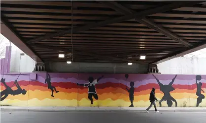  ??  ?? A pedestrian passes a mural on Chicago’s South Side. Photograph: Charles Rex Arbogast/AP