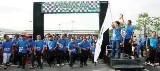  ??  ?? ... Perodua Sales Sdn Bhd managing director Zahari Husin sounds the air horn to flag off the 3km Perodua Fun Walk at the national car maker's 500-acre compound in Rawang, Selangor, yesterday in conjunctio­n with National Sports Day. With him is Perodua...