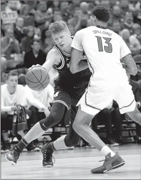  ?? AP/MICHAEL CONROY ?? Michigan forward Moe Wagner (left) drives on Louisville forward Ray Spalding (right) in the second half of the Wolverines’ 73-69 victory over the second-seeded Cardinals in the Midwest Regional in Indianapol­is, Ind. Wagner had a team-high 26 points for...