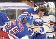  ?? Bruce Bennett / Associated Press ?? New York Rangers’ Ryan Lindgren, left, and Buffalo Sabres’ Dylan Cozens fight during the third period of an NHL game on Tuesday in New York.