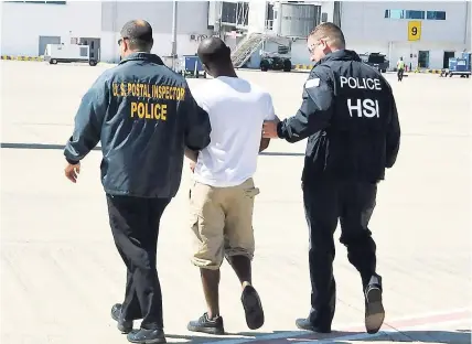  ??  ?? American law enforcemen­t officials escort an alleged lotto scammer who was being extradited to face trial in the United States.