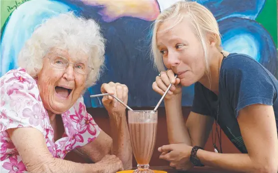  ?? Picture: GLENN HAMPSON ?? Doris James tries the stainless steel straws with Boomerang Bags founder Jordyn de Boer at The Raw Boys cafe in Tweed Heads.