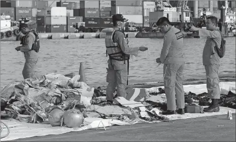  ?? TATAN SYUFLANA, FILE/AP PHOTO ?? Members of the Indonesian Search and Rescue Agency inspect debris recovered Monday from near the waters where a Lion Air passenger jet crashed at Tanjung Priok Port in Jakarta, Indonesia.