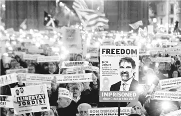  ??  ?? People hold a banners reading ‘Free political prisoners’ depicting an image of Catalan separatist leader Jordi Cuixart in Barcelona. — AFP photo