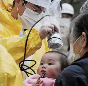  ?? Foto: LW-Archiv/Reuters ?? Nach dem Reaktor-Unglück in Fukushima werden die Menschen auf Radioaktiv­ität getestet.
