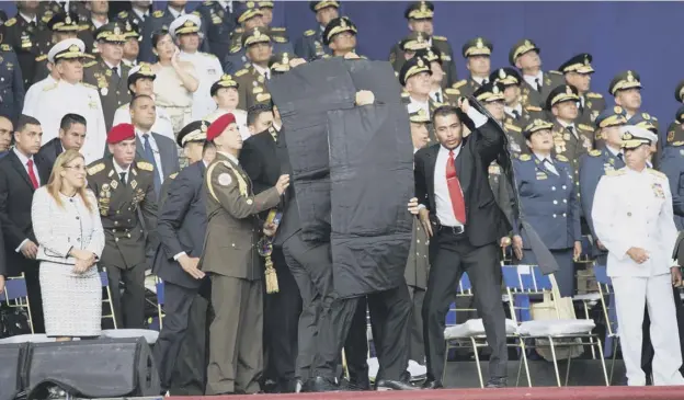  ?? PICTURES: AP ?? 0 Bodyguards escorted the Venezuelan leader out of the event after the two drones armed with explosives detonated