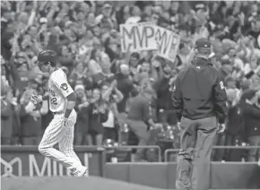  ?? ASSOCIATED PRESS ?? Fans at Miller Park hold up “MVP” signs as the Brewers’ Christian Yelich rounds the bases on his two-run homer in the third inning.
