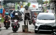  ?? DIMAS MAULANA/JAWA POS ?? BUTUH PERBAIKAN: Pengguna jalan menghindar­i orang-orangan yang dipasang di Jalan Raya Kemiri sebagai penanda lubang kemarin.