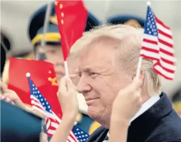  ??  ?? WARM WELCOME: Children wave US and Chinese flags as President Donald Trump arrives at Beijing Airport on Wednesday.