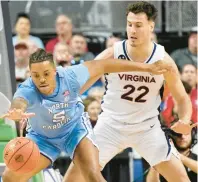  ?? CHUCK BURTON/AP ?? North Carolina forward Armando Bacot tries to hang on to the ball as Virginia center Francisco Caffaro defends during Thursday night’s ACC quarterfin­al.