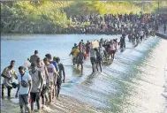  ?? AP ?? Migrants crossing the Rio Grande.
