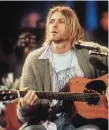  ??  ?? Music legend Kurt Cobain playing the 1959 Martin D-18E guitar at the centre of the trial