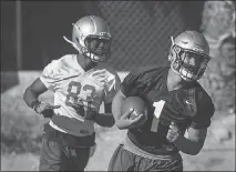  ?? L.E. BASKOW ?? UNLV redshirt freshman quarterbac­k Armani Rogers (1) runs the ball with receiver Devonte Boyd (83) trailing during a spring practice.