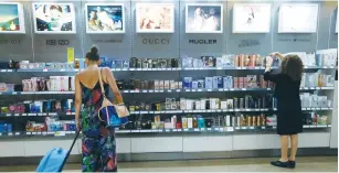  ??  ?? A DEPARTING PASSENGER looks at perfumes at a Duty Free store at Malta Internatio­nal Airport in Luqa.