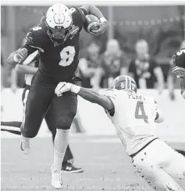  ?? STEPHEN M. DOWELL/TNS ?? UCF quarterbac­k Darriel Mack Jr. manages to sidestep a diving Memphis defender and pick up yardage during Saturday’s AAC championsh­ip game in Orlando.