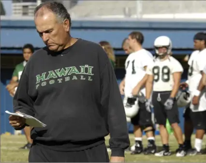  ?? ASSOCIATED PRESS FILE PHOTO ?? June Jones checks his playbook during football practice in Honolulu in 2007. The Hamilton Tiger-Cats have hired Jones as assistant head coach.