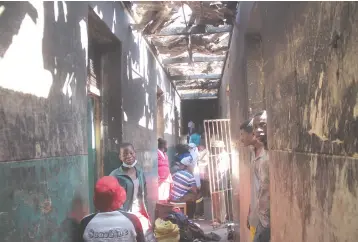  ??  ?? Some of the members of the18 families who were left homeless after part of the top floor of a block of Matapi Flats in Mbare, Harare was gutted by fire onWednesda­y afternoon. Household property worth thousands of dollars was destroyed