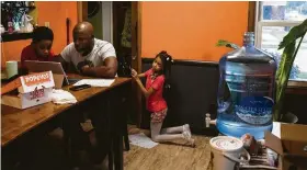  ?? Brittany Greeson / New York Times ?? Marcel Clark helps his son, Marcel Jr., 6, with his homework in Detroit, where contaminat­ion in school water fountains prompted officials to shut them down.