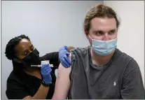  ?? BEN GRAY — THE ASSOCIATED PRESS ?? Cole Smith receives a Moderna variant vaccine shot from clinical research nurse Tigisty Girmay at Emory University’s Hope Clinic on March 31in Decatur, Ga. Smith received Moderna’s original vaccine a year ago in its first-stage study.