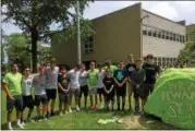  ?? ZACH SRNIS — THE MORNING JOURNAL ?? The Elyria Catholic High Schools Boys soccer team stands next to the completed rock honoring Jakob Hwang.