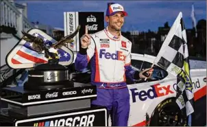  ?? Matt Slocum / Associated Press ?? Denny Hamlin celebrates after winning the NASCAR Cup Series auto race at Pocono Raceway last year. Hamlin and Kevin Harvick flipped their 1-2 finish in Pocono’s doublehead­er weekend last year but they each come back for this weekend’s races winless and trying to chase Kyle Larson.