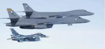  ??  ?? > In this photo released by Japan Air Self Defense Force, US Air Force B-1B bombers, top, fly with a Japan Air Self Defense Force F-2 fighter jet over Japan’s southern island of Kyushu, just south of the Korean Peninsula, during a Japan-U.S. joint...