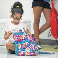  ??  ?? Aleeah DeLuna, 8, organizes her new backpack during City Council District 3’s back-to-school health fair at UIW’s School of Osteopathi­c Medicine at Brooks City Base.