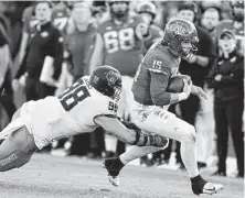  ?? Charlie Neibergall / Associated Press ?? Iowa State quarterbac­k Brock Purdy, right, runs from Oklahoma State’s Brendon Evers during Saturday’s game.