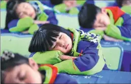  ?? LIU QINLI / FOR CHINA DAILY ?? Elementary school students practice a healthy position for napping in Bozhou, Anhui province, on Wednesday, which was World Sleep Day.