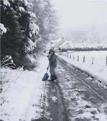  ??  ?? 0 Clockwise from above: A resident clears snow on a road in Lamancha in the Borders; a family build a snowman on Arthur’s Seat in Edinburgh; also in the capital, a running club brave the conditions for a good workout; and a walker heads for the summit...