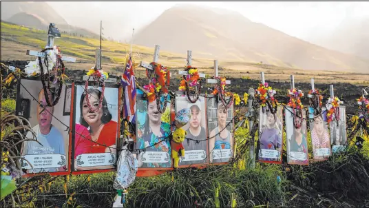  ?? Lindsey Wasson The Associated Press ?? Photos of a few of the victims of the August 2023 Maui wildfire are displayed under white crosses at a memorial above the Lahaina Bypass highway on the Hawaiian island on Dec. 6. The Maui Fire Department released a detailed report on the fire on Tuesday.