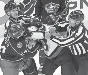  ?? ADAM CAIRNS/COLUMBUS DISPATCH ?? Referees try to separate Blue Jackets right wing Mathieu Olivier from Jets defenseman Nate Schmidt during a game in February.