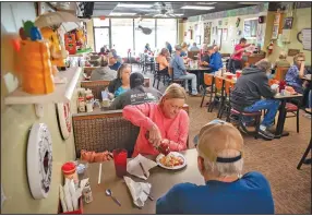  ?? (The New York Times/Rory Doyle) ?? Customers, many not wearing masks, dine at a restaurant Saturday in Southaven, Miss. Some states, including Mississipp­i and Texas, have continued lifting restrictio­ns, including mask mandates, despite warnings from top federal health officials like Dr. Anthony Fauci.