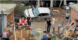  ?? PHOTO: REUTERS ?? People are seen cleaning mud following floods in Livorno, Italy.