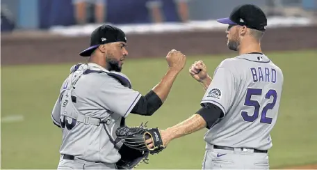  ?? Kelvin Kuo, The Associated Press ?? Rockies reliever Daniel Bard, right, celebrates with Elias Diaz after defeating the Los Angeles Dodgers on Sunday night in Los Angeles.