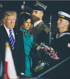  ?? AP/CZAREK SOKOLOWSKI ?? President Donald Trump and his wife, Melania, are greeted by an honor guard Wednesday as they arrive in Warsaw, Poland, for a visit ahead of the Group of 20 meeting in Hamburg, Germany.