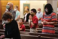  ?? Photo for The Washington Post by Oliver Contreras ?? Andre Kuhner, left, attends his first Mass in two months with his wife Renata, right, and their two sons at the Cathedral of Saint Thomas More in Clarendon, Virginia, on Sunday, May 31, 2020.